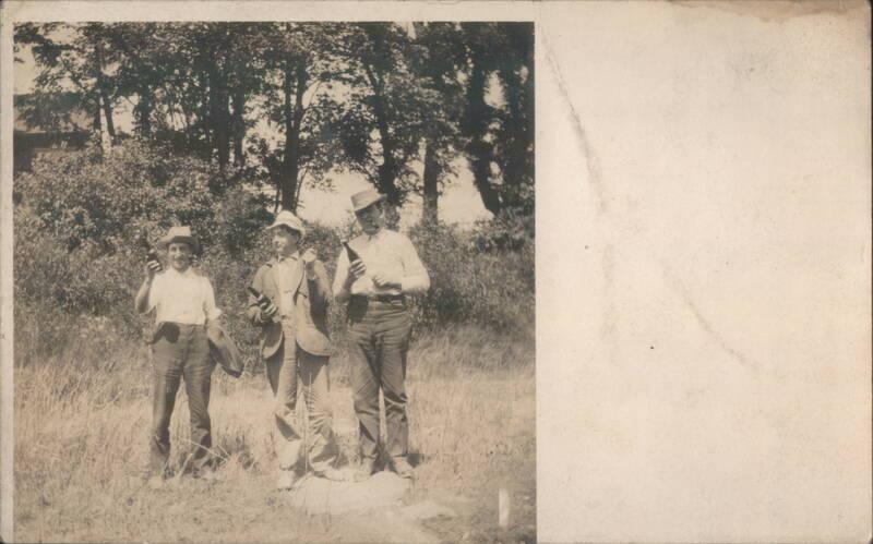 Three Men Standing in a Field with Bottles