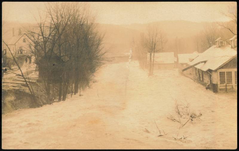 Raging Flood Waters Along Mill Buildings and Houses