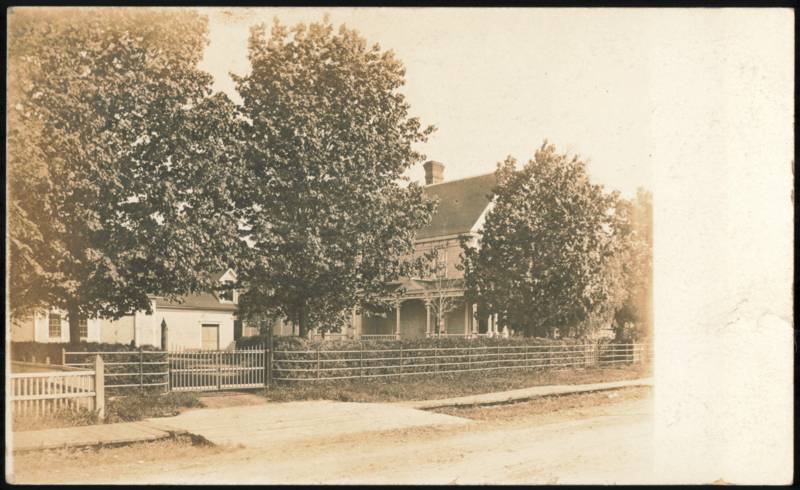 Large House with Wrap-Around Porch and Fence Buildings