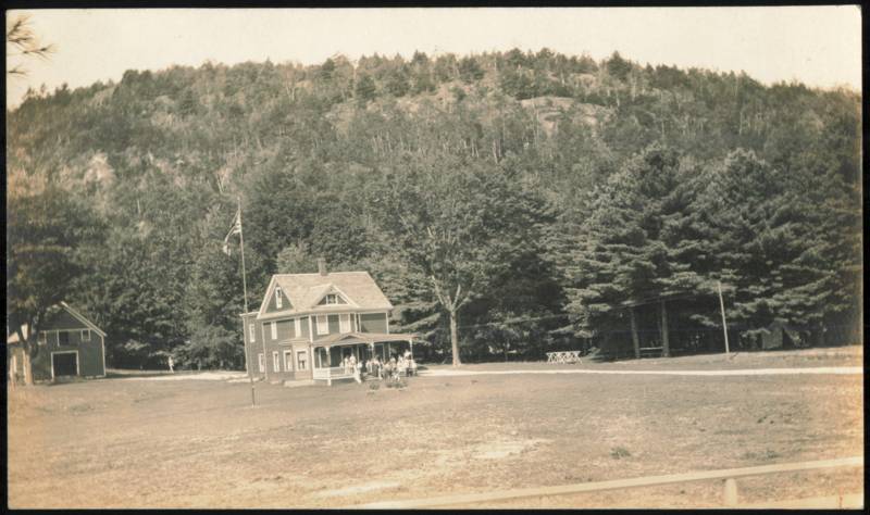 Group of People Gathered at a House with a Flagpole