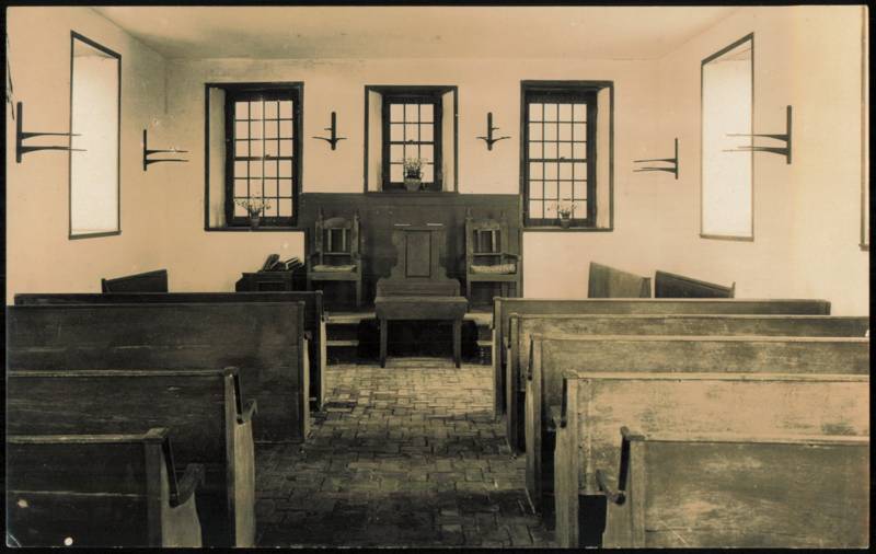 Historic Church Interior with Wooden Pews and Brick Floor