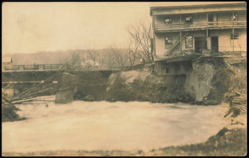 Raging Flood Waters Undermining Riverbank Building