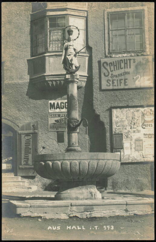 Historic Fountain with Madonna Statue and Advertisements Hall in Tirol Austria