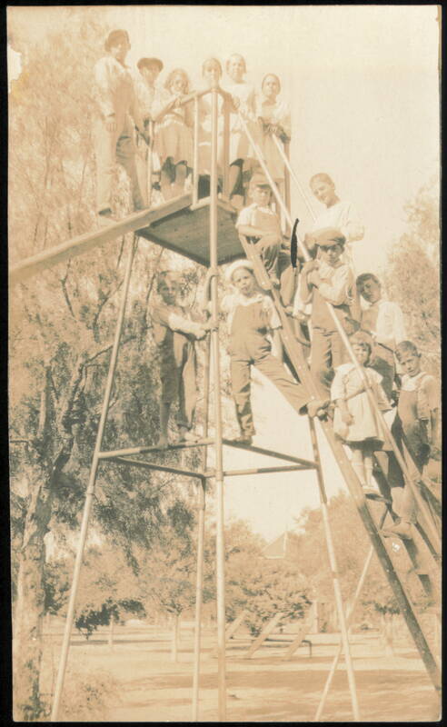 Children Posing on Tall Playground Slide