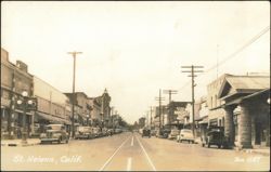 Downtown Main Street with Storefronts and Parked Cars Postcard