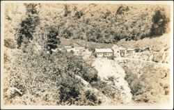 Mining Camp Buildings and Wooden Trestle on Mountainside Postcard