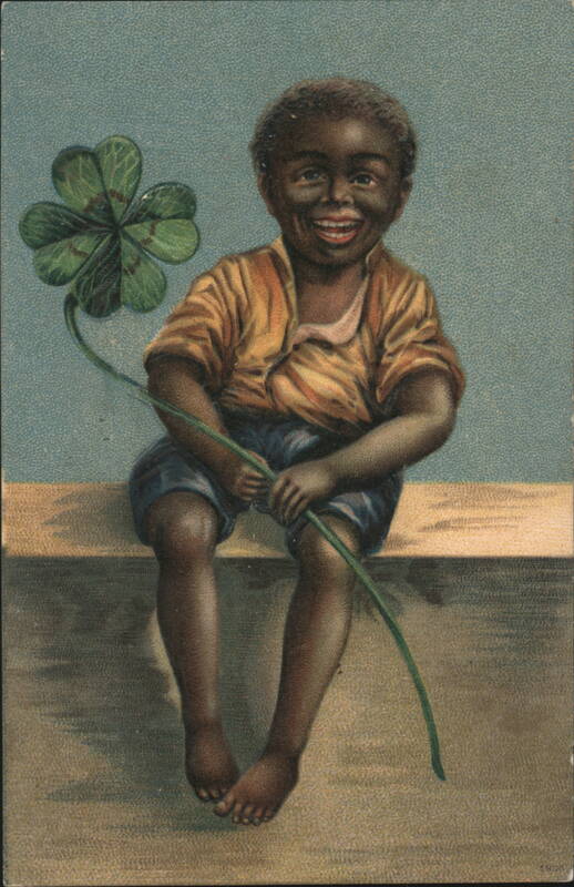 Smiling Black Boy Sitting with Large Four-Leaf Clover