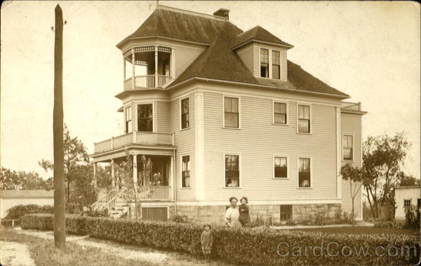 Three story home with family in yard Unidentified People