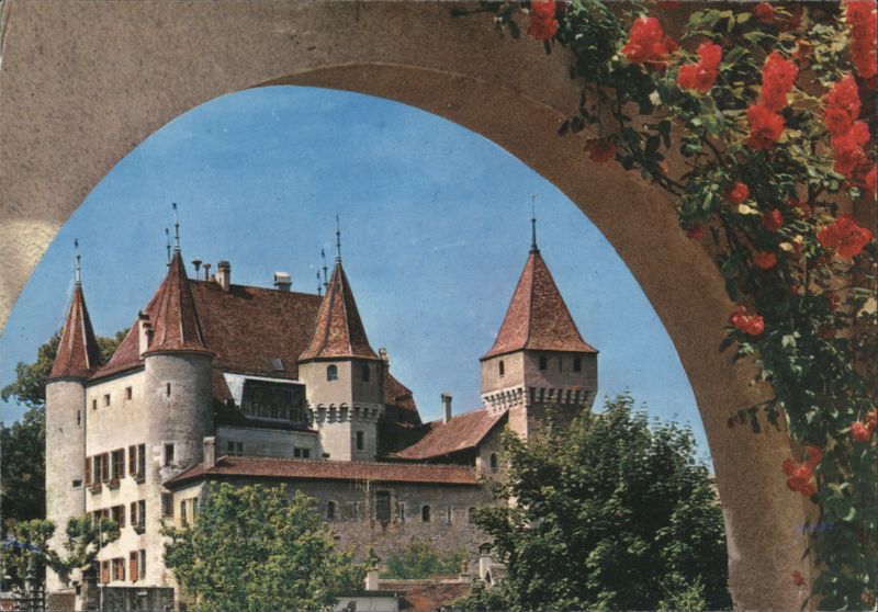 Château de Nyon framed by an arch and climbing roses Switzerland
