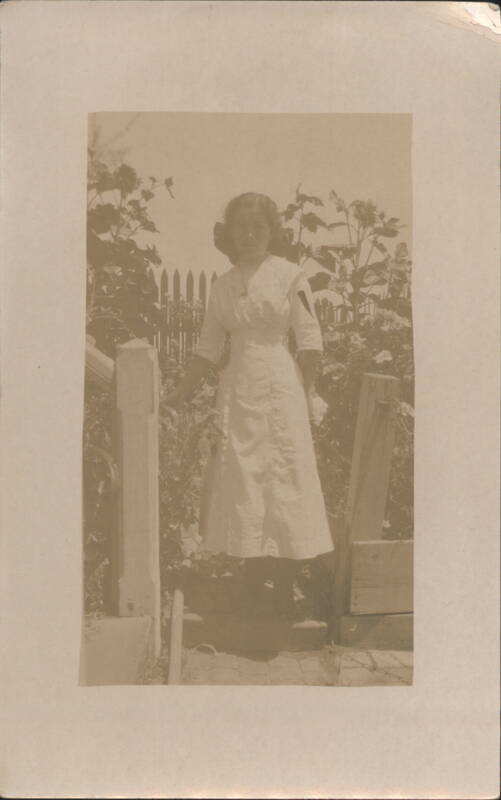 Young Woman in White Dress by Picket Fence & Sunflowers