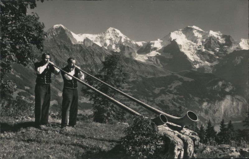Alphorn Players with Eiger, Mönch, and Jungfrau Mountains Switzerland
