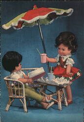 Dolls Reading & Serving Drinks Under Umbrella Postcard