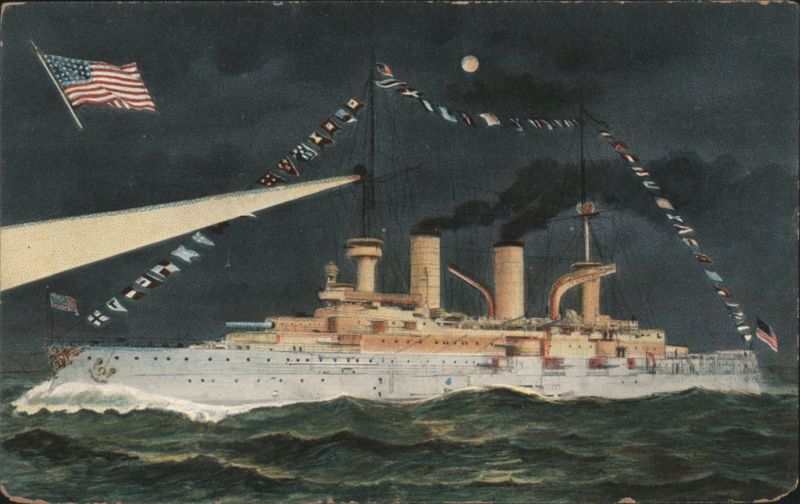 US Navy Battleship Illuminated at Night with Flags and Searchlight