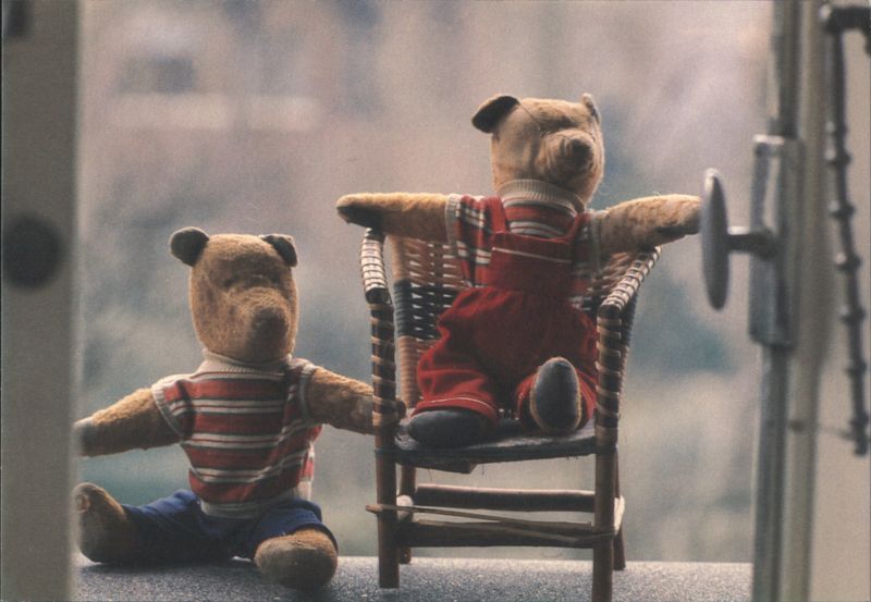 Two Teddy Bears on Chair and Floor Looking Out Window