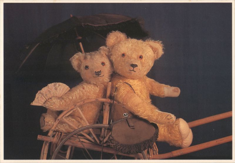 Two Teddy Bears on a Wooden Rocking Toy with Umbrella and Fan