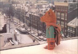 Teddy Bear on Snowy Rooftop Overlooking Amsterdam Canal Postcard