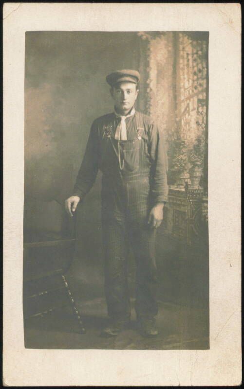 Man in Overalls and Cap with Medals Occupational