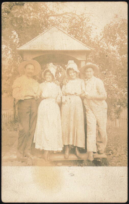 Four People in Hats by Wooden Structure Family Portaits