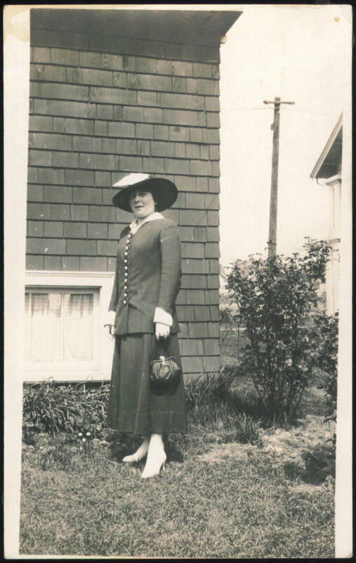 Woman in Hat and Suit Holding Purse Women