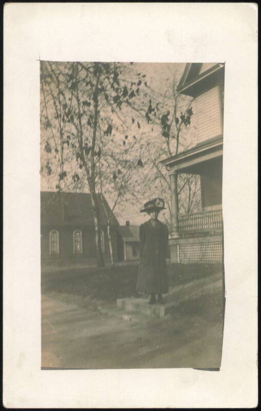 Woman in Hat Standing on Steps of House Women