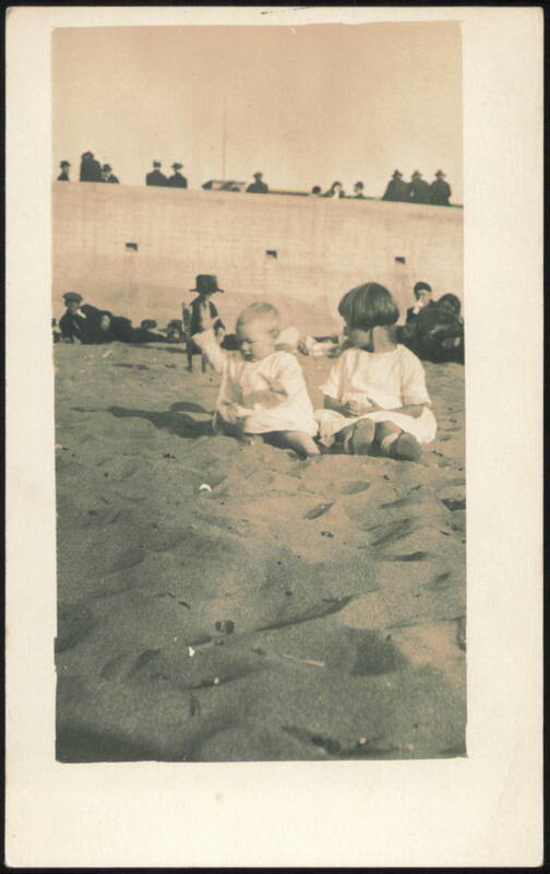 Two Children on Beach with Adults in Background Babies