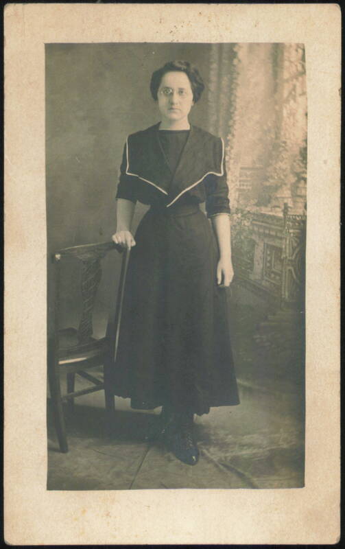 Woman in Glasses & Dark Dress with White Collar Women