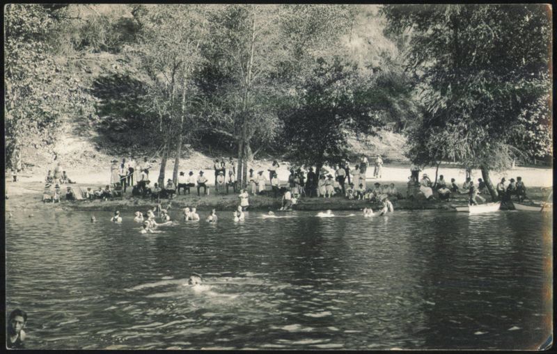 People Swimming and Relaxing by a River Unidentified People