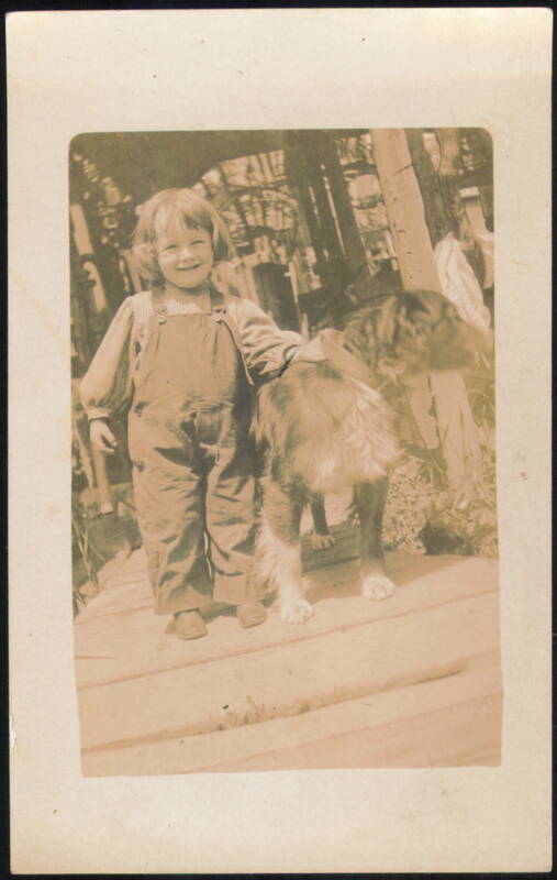 Smiling Child in Overalls with Large Dog Children