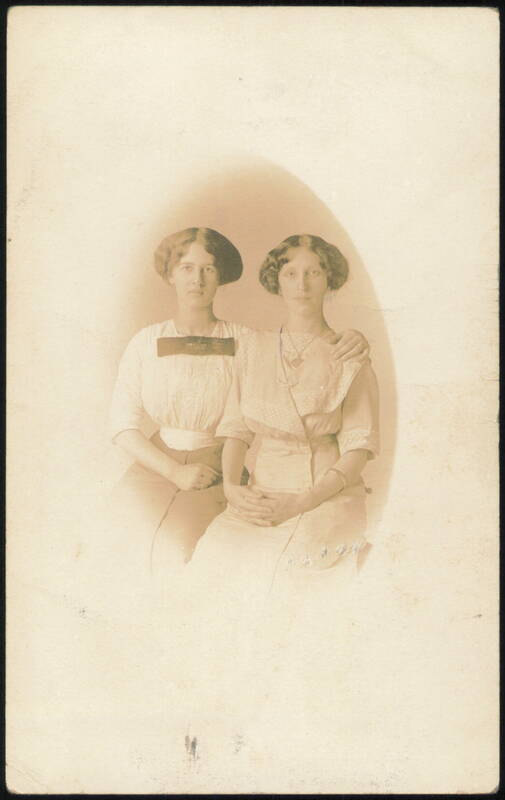 Two Young Women Seated Arm in Arm