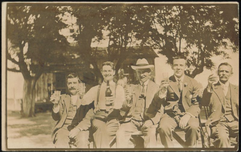 Five Men Toasting with Drinks Outdoors