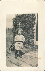 Child in Smock and Boots on Wooden Walkway Postcard