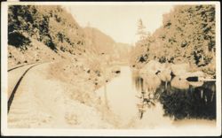 Railroad Tracks along River in Mountainous Landscape Postcard