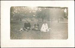Man & Two Women Picnicking in Park Postcard