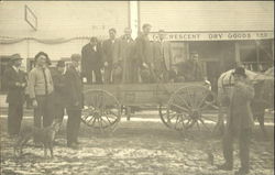 Men standing in a wagon in front of the dry goods store Men standing in a wagon in front of the dry goods store