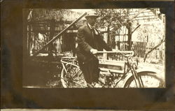 Man riding an early motorcycle Man riding an early motorcycle