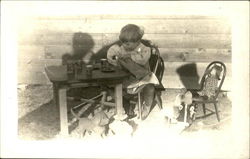 Child having tea party with her doll Child having tea party with her doll