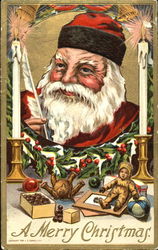 Santa writing, with candles and toys Postcard