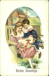Boy and girl sitting with a lamb in her lap Postcard