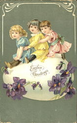 Three pretty children sitting on a huge Easter egg Postcard