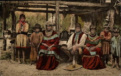 Family of Seminole Indians near a chickee (home) Postcard