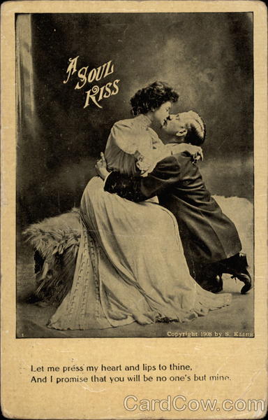 Man and woman embrace and kiss, with man kneeling and woman sitting