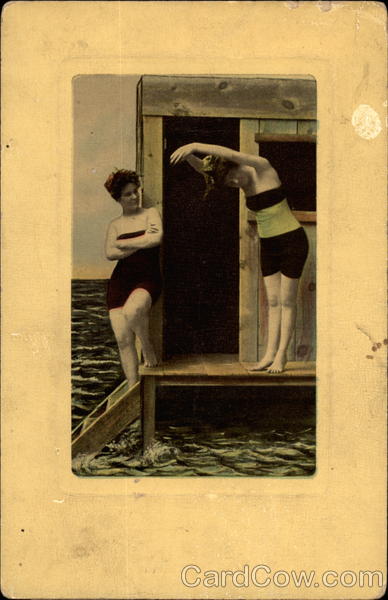 Two ladies in old-fashioned bathing suits post by the sea