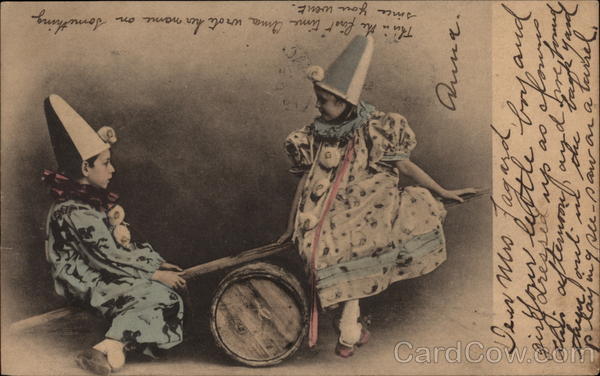 Girl and Boy in Clown Costumes on a See Saw Children