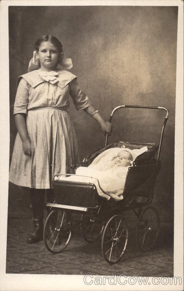 Girl standing next to baby in baby buggy Girls