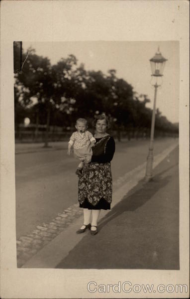 Woman Holding a Baby by a Streetlamp Women