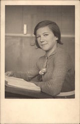 GIrl Sitting at Desk with a Book Postcard