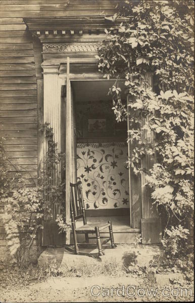 Rocking chair on front step, holding door to house open Northampton Massachusetts