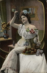 Woman in Long White Gown Holding Up Bunch of Grapes Postcard