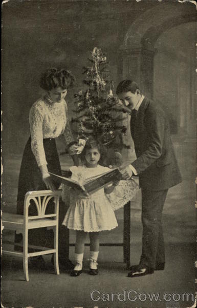 Man, Woman and Girl in front of Christmas Tree Children
