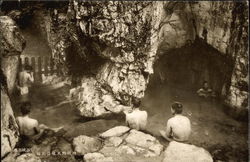 Men on rocks in outdoor bath house Postcard